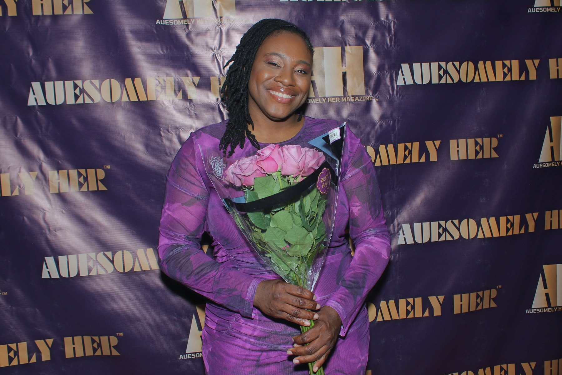 Dr. Crystal Jordan, L.H.D., wearing a purple dress at an Auesomely Her event